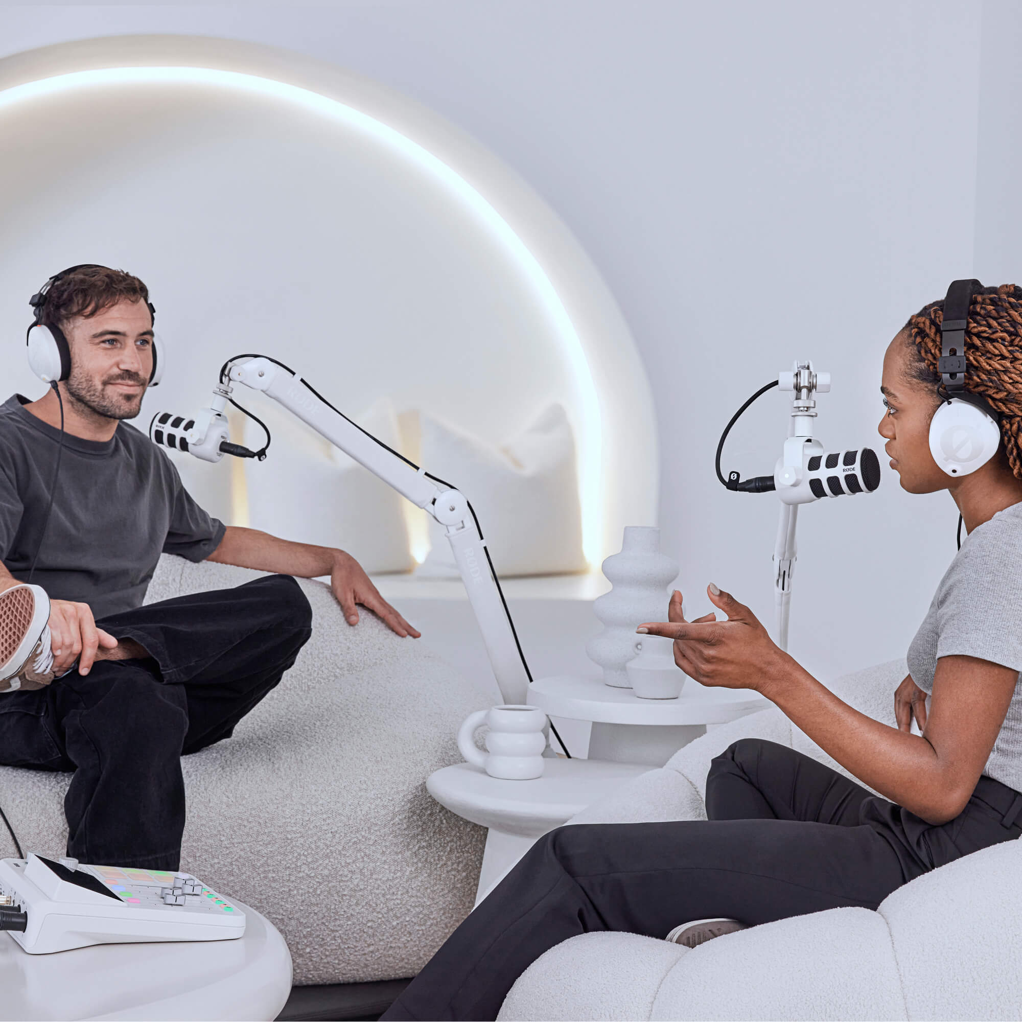 Bílé rameno RØDE PSA1+ a bílý PodMic ve světlém podcastovém studiu